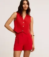 Short blanco de sastrería con cintura alta, bolsillos laterales con tachuelas metalizadas, recortes delanteros con costura aparente, bolsillos falsos y pinzas traseras.