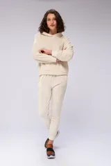 Conjunto deportivo color crema compuesto por un hoodie con capucha y un pantalón jogger con puños ajustados.