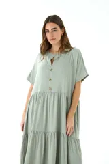Vestido largo color verde salvia, de lino, con cuello mao, mangas cortas y corte escalonado con volados.