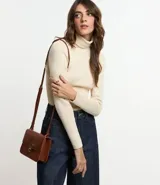 Suéter de punto color blanco, con cuello alto estructurado, manga larga y efecto texturizado.