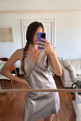 Vestido corto color plateado, con escote en V y espalda descubierta.