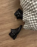 Botines negros de cuero vacuno con correas y hebillas metálicas.