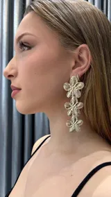 Aros colgantes dorados con tres flores caladas.