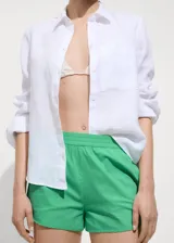Short verde con cintura elástica, bolsillos delanteros y diseño recto.
