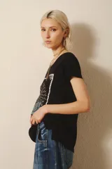 Remera negra de algodón y modal con estampa de un girasol y la frase "Peace of Mind".