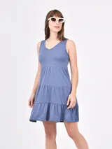 Vestido corto color coral, de corte suelto y sin mangas, con escote en V y falda escalonada con volantes.