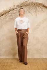 Pantalón ancho color beige de lino con cinto y pretina con elástico en la parte de atrás.