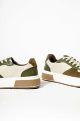 Zapatillas deportivas de cuero color beige, con detalles en verde oliva y marrón.