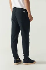 Pantalón de jogging negro de felpa con puños y cintura ajustable con cordón. Presenta logo de goma en la pierna izquierda y bolsillos laterales.