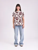 Remera estampada con motivos florales en tonos naranja, beige, gris y rosa.