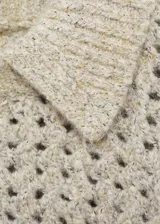 Sweater beige de punto calado con cuello polo y terminaciones acanaladas.