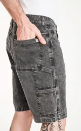 Bermuda de denim gris con efecto desgastado, corte oversize estilo carpintero y múltiples bolsillos.