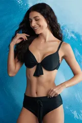 Traje de baño de dos piezas con estampado animal print de cebra en tonos marrones. El corpiño es de corte clásico con copa y moño en el centro. La bombacha es de tiro alto con lazos en los laterales.