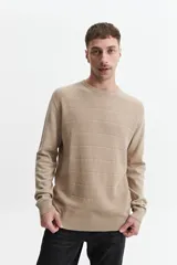 Buzo de punto color beige, con cuello redondo y mangas largas. Tejido con textura piquet y puños acanalados. Corte regular.