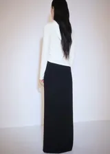 Camiseta blanca de tejido fluido con cuello redondo, capucha y mangas largas.