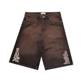 Bermuda de jean color marrón con lavado gastado, corte baggy, bolsillos grandes y bordados ornamentales en los laterales.