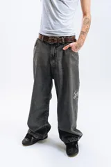 Pantalón de jean azul oscuro con efecto desgastado, corte mega baggy, bolsillos grandes y bordado lateral con el logo de la marca en color blanco.