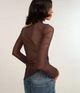 Blusa de manga larga confeccionada en tule color marrón con estampado abstracto. Presenta escote asimétrico, transparencia en mangas y espalda, fruncido lateral y bajo asimétrico.