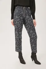 Pantalón babucha negro con estampado floral en tonos celeste y blanco.