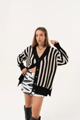 Saco oversize tejido a rayas verticales en blanco y negro, con escote en V y botones.