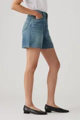 Short de jean celeste de tiro alto, corte holgado y largo a la rodilla.