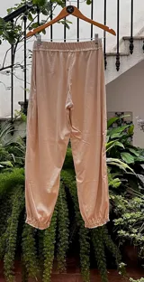 Pantalón tipo babucha color naranja, con cintura y puños elastizados, bolsillos delanteros y confeccionado en algodón.