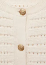 Chaqueta color crema de tejido de punto calado con mezcla de lana, cuello redondo y cierre frontal con botones.