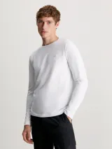 Remera blanca de manga larga Calvin Klein, corte slim, cuello redondo y parche con logo en el pecho.