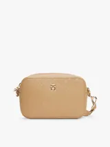 Bandolera Tommy Hilfiger color beige con monograma TH en relieve, cierre de cremallera, correa de cadena dorada extraíble y ajustable, bolsillo interior con cremallera, monedero extraíble con cremallera y logo TH dorado en el frente.