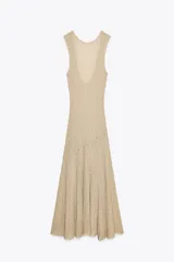 Vestido midi de encaje color beige, sin mangas, con espalda descubierta y bajo asimétrico con volados.