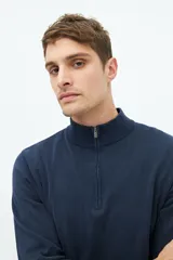 Buzo de punto color gris claro con medio cierre, cuello alto y logo bordado.