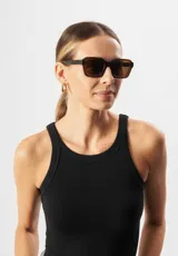 Lentes de sol Eco Shades modelo Romano con montura cuadrada azul traslúcido y lentes grises. Fabricados con acetato biodegradable y lentes de PMMA reciclado.