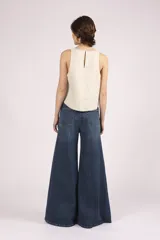 Blusa sin mangas color crema, con cuello redondo y bordes con pespuntes en contraste.
