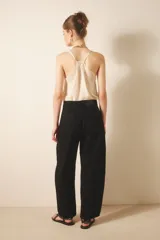Pantalón jean negro de tiro medio y calce holgado, confeccionado en denim rígido con lavado suavizado.