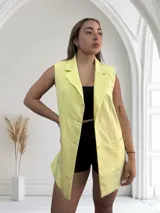 Chaleco sastrero largo color amarillo pastel, con solapas y cierre con dos botones.