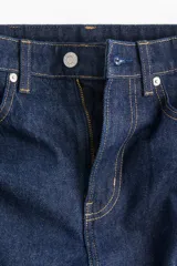 Pantalón de jean azul oscuro, de tiro alto, corte holgado y pierna ancha.