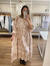 Vestido midi de viscosa azul con estampado floral beige, corte holgado, cuello camisero y mangas largas con puños acampanados.