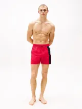 Short de baño rojo con cintura elástica ajustable con cordón, logo de Tommy Hilfiger estampado en el lateral y detalles en azul marino y blanco.