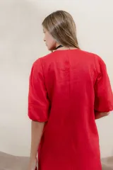 Vestido largo rojo con escote en V, mangas abullonadas con elástico en el puño y detalle de pespunte en contraste. Presenta un canesú con efecto punto smock y bolsillos laterales.