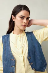 Camisa blanca de algodón con cuello mao, mangas abullonadas con puños abotonados y calados centrales.
