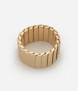 Pulsera dorada con elástico y textura de escamas sobrepuestas.