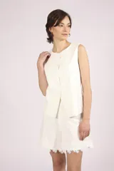 Chaleco negro sin mangas, con cuello redondo y cierre frontal de botones. Presenta detalles de encaje o apliques en los laterales y un corte ligeramente holgado.