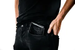 Billetera negra de cuero con cierre perimetral, compartimentos internos para tarjetas, billetes y monedas.