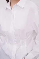 Camisa blanca de algodón con ajuste al cuerpo y mangas largas.