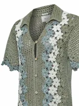 Chaleco tejido a crochet con diseño de flores en tonos beige y crudo, con cuello camisero y cierre frontal con botones de madera.
