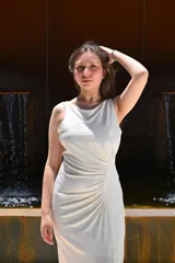 Vestido largo color blanco hueso, de fiesta, con escote redondo, sin mangas y abertura lateral en la falda.