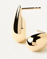 Aros colgantes dorados con forma de gota.