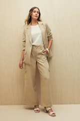 Pantalón color beige de tiro alto, corte wide leg y bolsillos laterales tipo cargo.