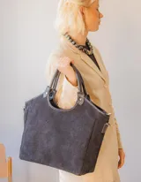 Cartera tipo tote bag de gamuza color azul marino, con doble asa corta y correa larga desmontable.