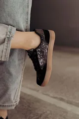 Zapatillas bajas color beige con estampado de piel de serpiente metalizada, cordones blancos y suela color caramelo.